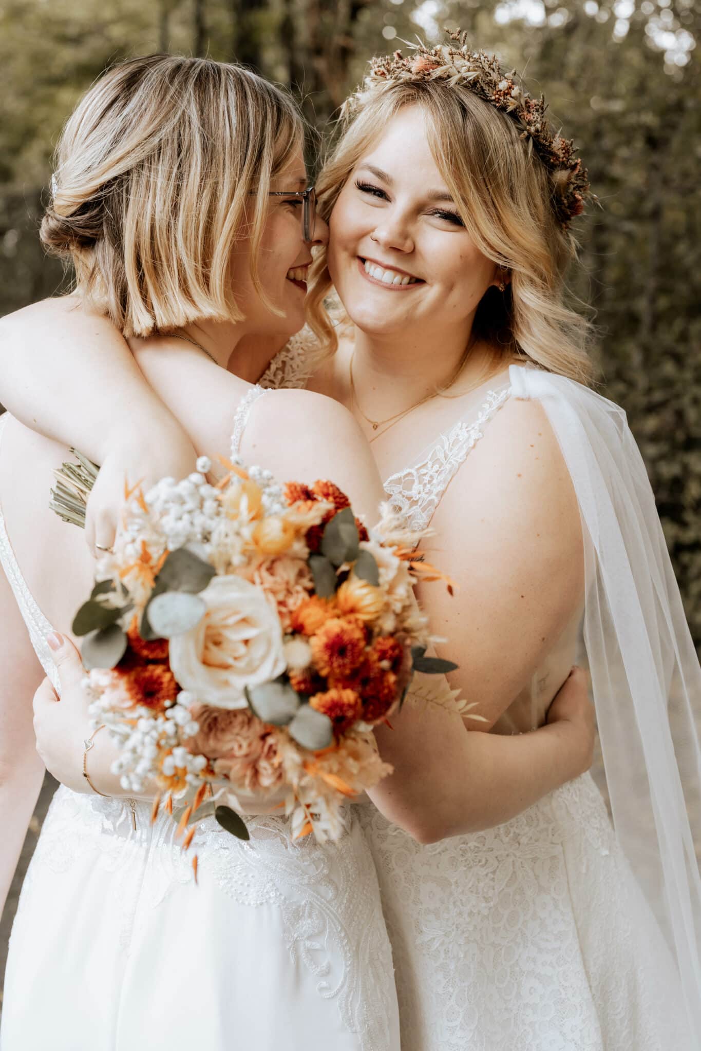 Lesbisches Hochzeitspaar was sich umarmt.