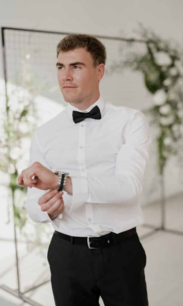 Hochzeitsfotograf Borken 3 Bräutigam steckt sich eine Uhr an das linke Handgelenk.